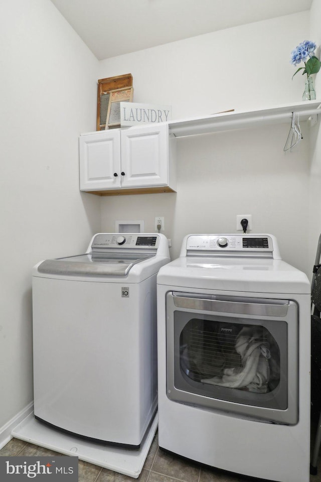 washroom with tile patterned flooring, cabinet space, and washer and dryer