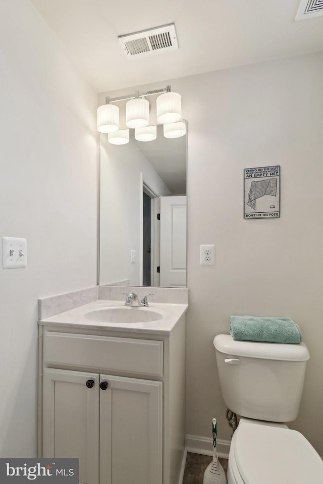 bathroom with baseboards, visible vents, vanity, and toilet