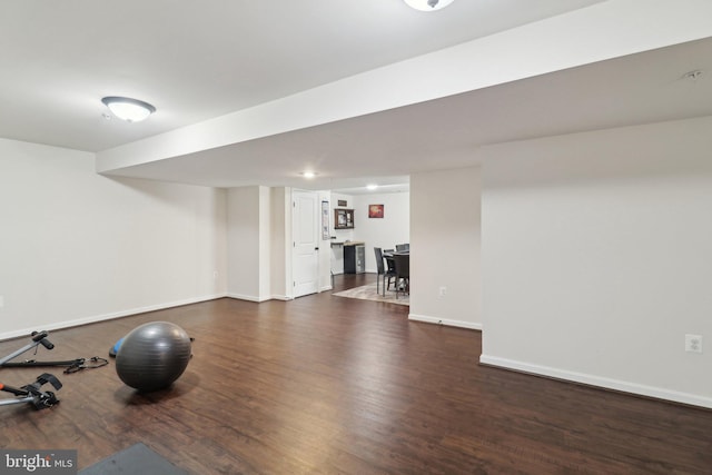 workout room with baseboards and dark wood-type flooring