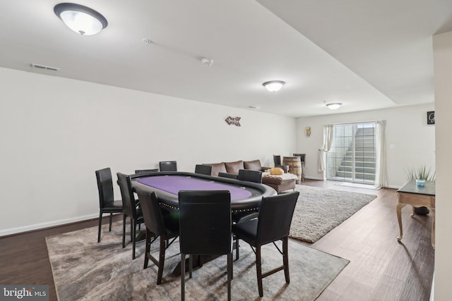 dining area with baseboards, visible vents, and wood finished floors