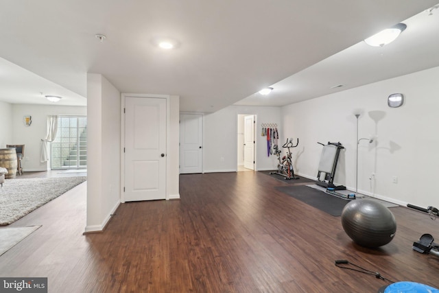 workout room with baseboards and dark wood-style flooring