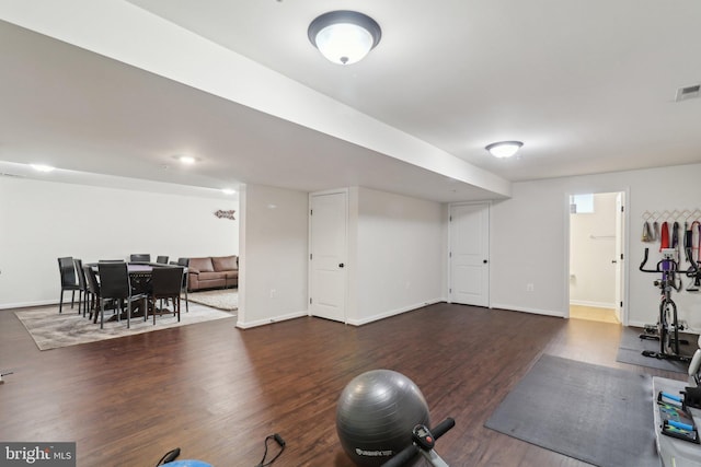 workout area with wood finished floors, visible vents, and baseboards