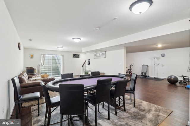 dining space with stairs, baseboards, and wood finished floors