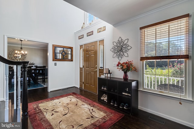 foyer featuring visible vents, a chandelier, a wealth of natural light, and ornamental molding