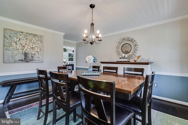 dining area with baseboards, ornamental molding, a chandelier, and wood finished floors