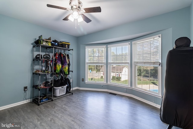 interior space with baseboards, visible vents, ceiling fan, and wood finished floors