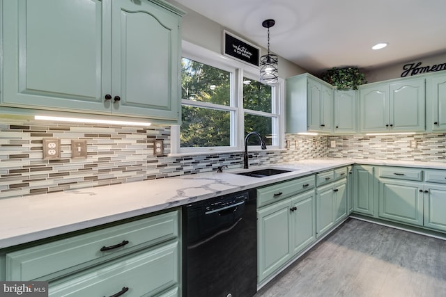 kitchen with light wood-style floors, black dishwasher, a sink, and tasteful backsplash