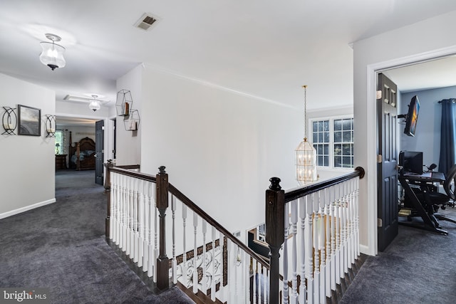 hallway featuring carpet, a notable chandelier, visible vents, an upstairs landing, and baseboards