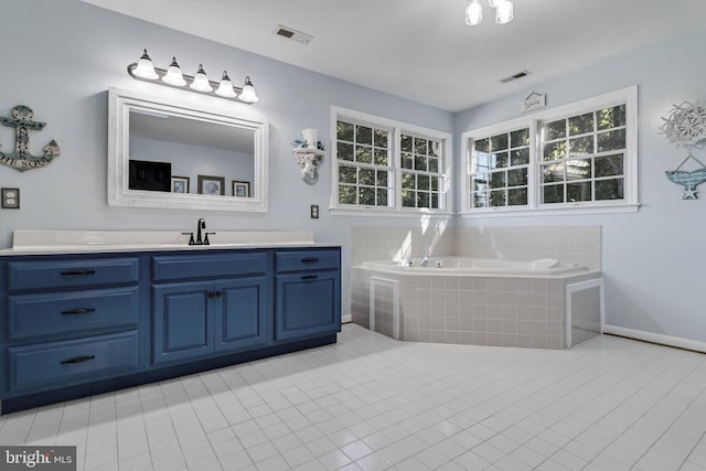 bathroom with tile patterned floors, visible vents, a bath, and vanity