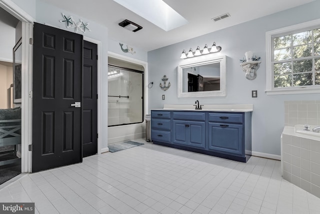 bathroom featuring a skylight, visible vents, baseboards, tile patterned flooring, and vanity