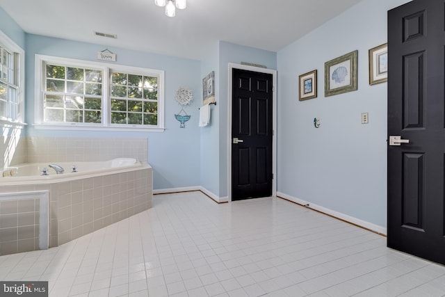 full bathroom with tile patterned flooring, a garden tub, visible vents, and baseboards