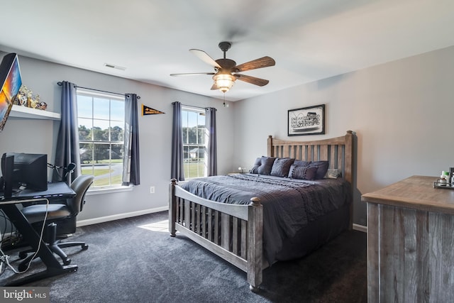 bedroom with baseboards, visible vents, dark carpet, and a ceiling fan