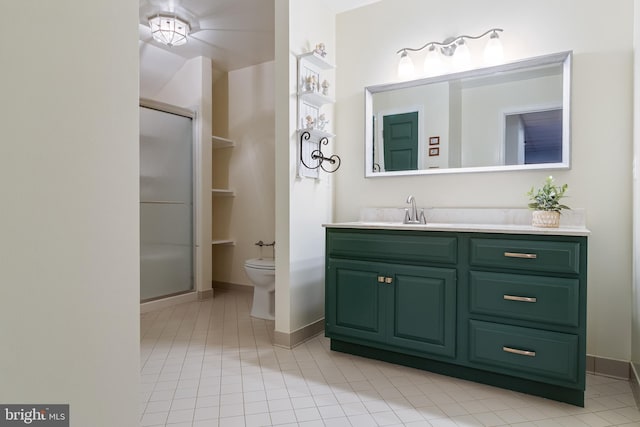 bathroom featuring toilet, a stall shower, baseboards, and vanity