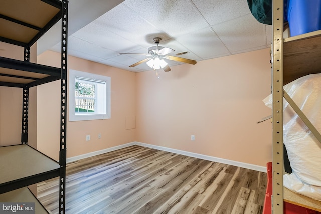 unfurnished bedroom with visible vents, wood finished floors, a paneled ceiling, and baseboards