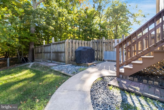 view of yard featuring a fenced backyard and stairs