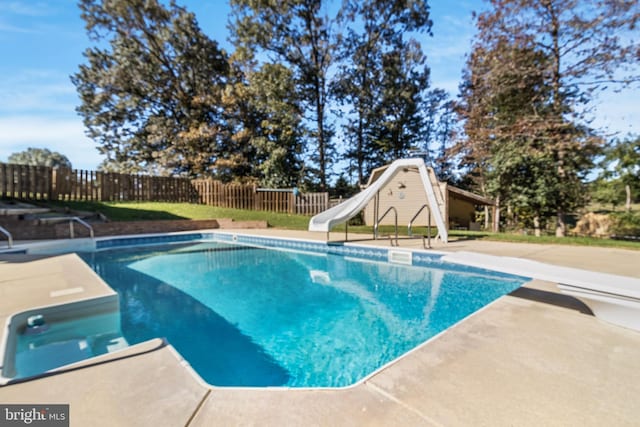 view of pool with a fenced in pool, a water slide, a patio area, and fence