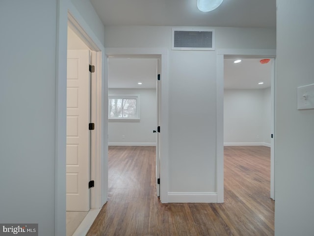 hall featuring recessed lighting, visible vents, baseboards, and wood finished floors