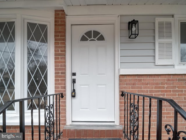 view of exterior entry with brick siding