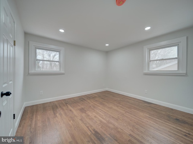 spare room with recessed lighting, wood finished floors, and baseboards