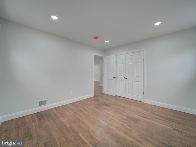 unfurnished bedroom with baseboards, visible vents, wood finished floors, and recessed lighting