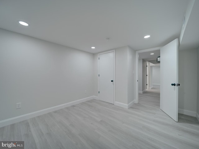 spare room featuring recessed lighting, light wood-type flooring, and baseboards