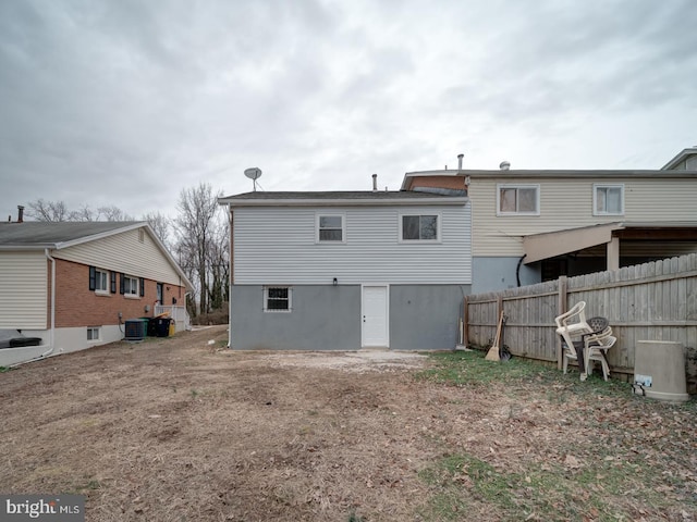 back of property with central AC and fence