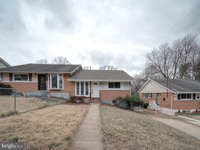 view of front of property with a front yard, fence, and brick siding