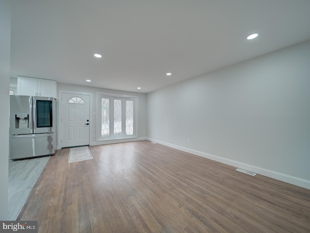 interior space with light wood-style flooring, visible vents, baseboards, and recessed lighting