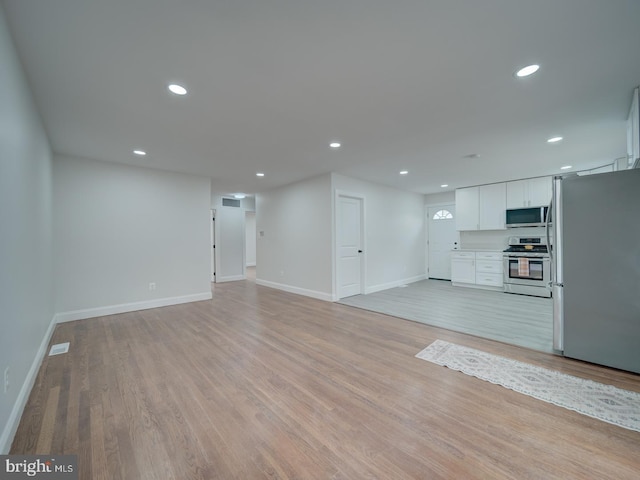 unfurnished living room featuring light wood-style floors, visible vents, baseboards, and recessed lighting