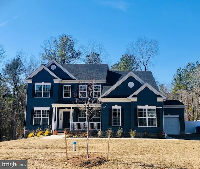 view of front of property with a porch, a garage, and a front yard