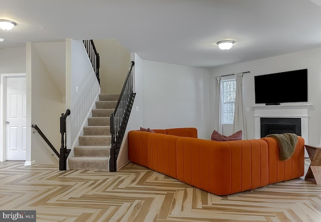 living area featuring stairway and a fireplace