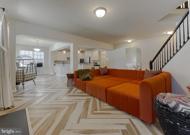 living area with stairs and baseboards