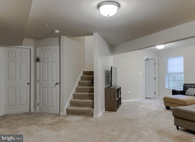 interior space with light carpet, stairway, and baseboards