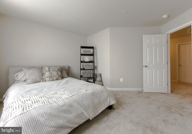 bedroom with baseboards and light colored carpet