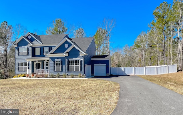 view of front of home with fence, a porch, a front yard, a garage, and driveway