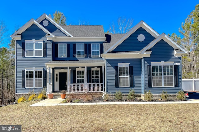 view of front of home featuring covered porch and a front lawn