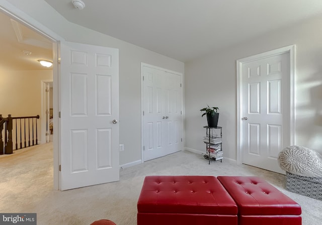 living area featuring carpet and baseboards