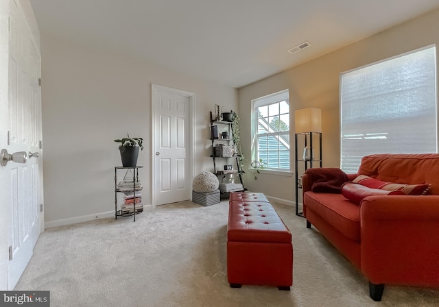 living area featuring visible vents, baseboards, and carpet