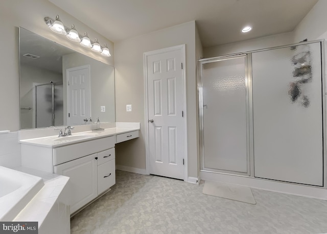 full bathroom with visible vents, baseboards, a bathtub, a stall shower, and vanity