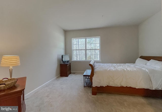 bedroom with light colored carpet and baseboards