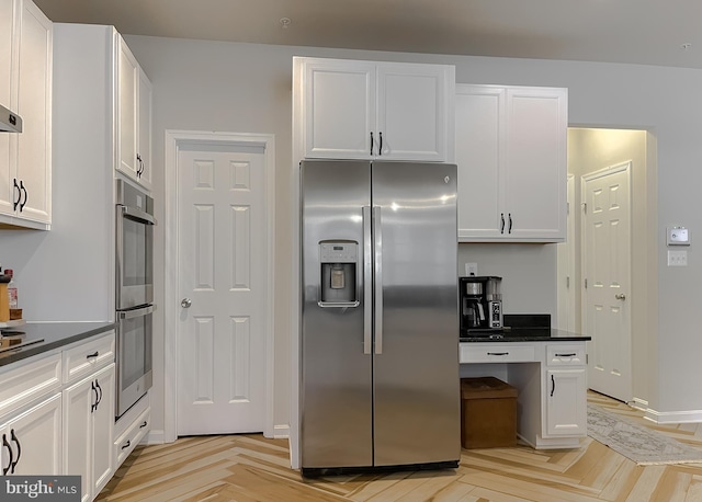 kitchen featuring white cabinetry, dark countertops, and appliances with stainless steel finishes