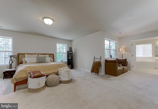 carpeted bedroom featuring connected bathroom and baseboards