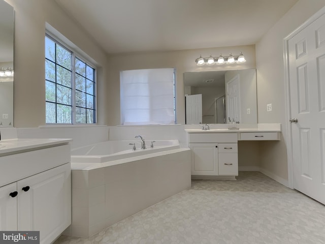 bathroom featuring two vanities, a shower stall, a bath, and a sink