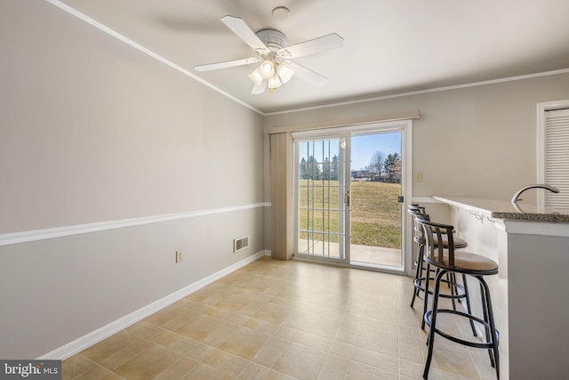 dining space with a ceiling fan, crown molding, baseboards, and visible vents