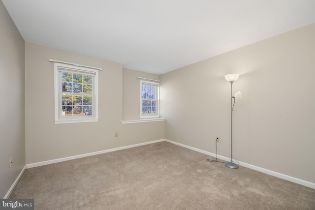 spare room featuring carpet flooring and baseboards