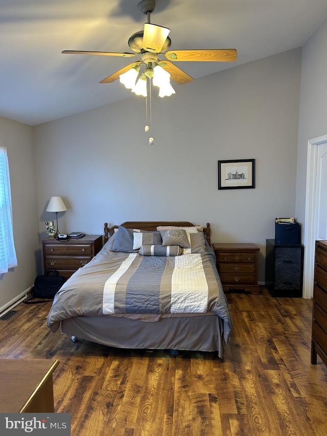 bedroom with ceiling fan, vaulted ceiling, and wood finished floors