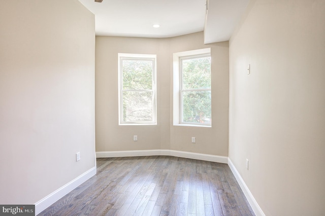 unfurnished room with baseboards and wood finished floors