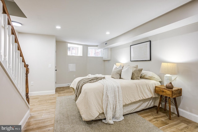 bedroom with baseboards, recessed lighting, and light wood-style floors