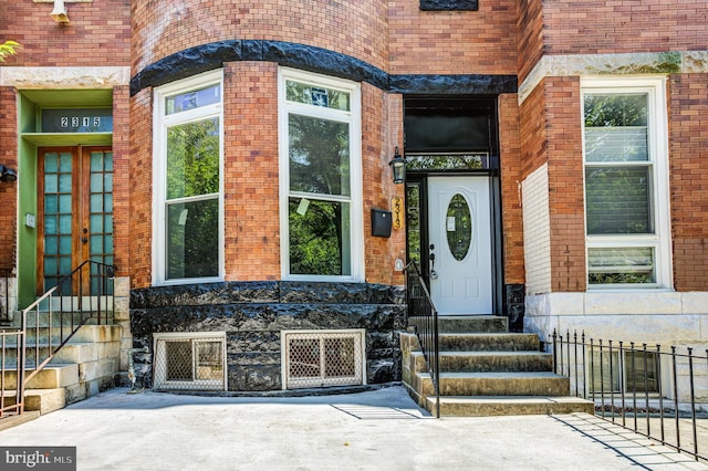 entrance to property featuring brick siding