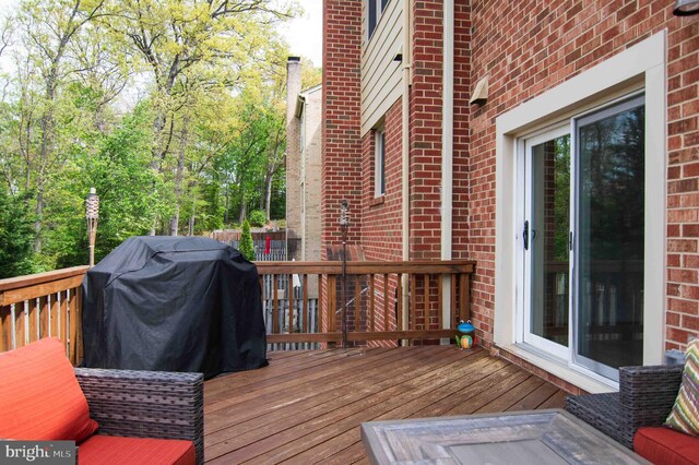 wooden deck featuring a grill